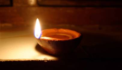A lit clay diya on a windowsill during Diwali