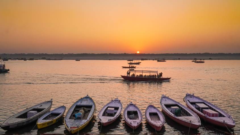 Varanasi ghats lit with rows of earthen diyas along the Ganga at dusk